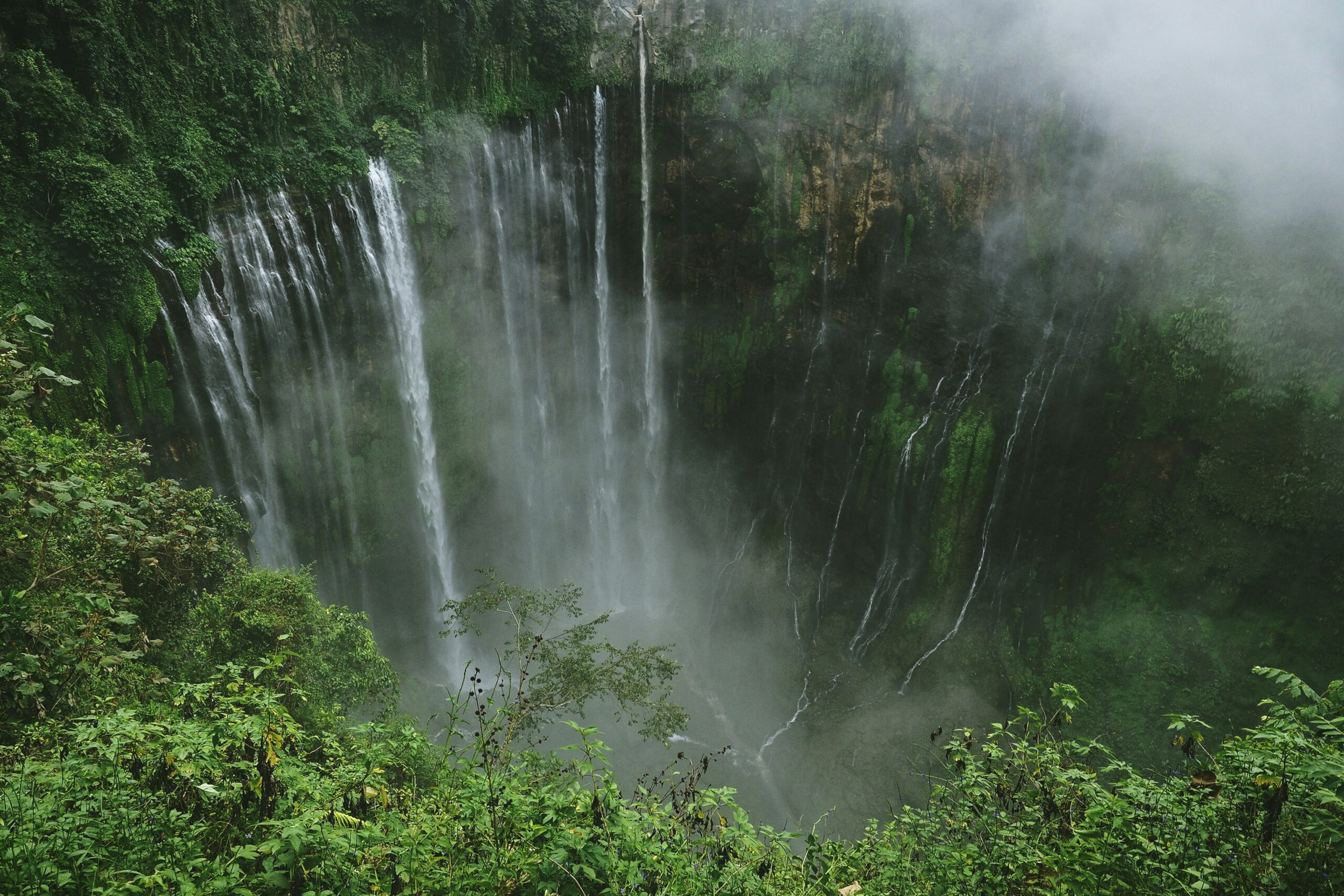 Tumpak Sewu Waterfall, often called the “Niagara of East Java,” is a breathtaking natural wonder with hundreds of water streams cascading down a dramatic semicircular cliff. Located on the border of Lumajang and Malang, this waterfall is surrounded by lush tropical forests and offers a spectacular view with Mount Semeru as its majestic backdrop. The cool atmosphere, the thunderous sound of falling water, and the pristine landscape make Tumpak Sewu a must-visit destination for nature lovers, adventurers, and photography enthusiasts.